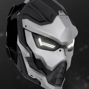 May include: A futuristic, white and black helmet with a visor and a black strap. The helmet has a geometric design and a series of small, round holes on the side.
