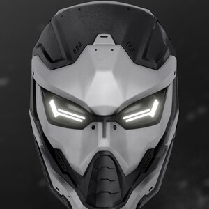 May include: A futuristic white and black helmet with a visor and glowing lights. The helmet has a textured surface and a sleek design.