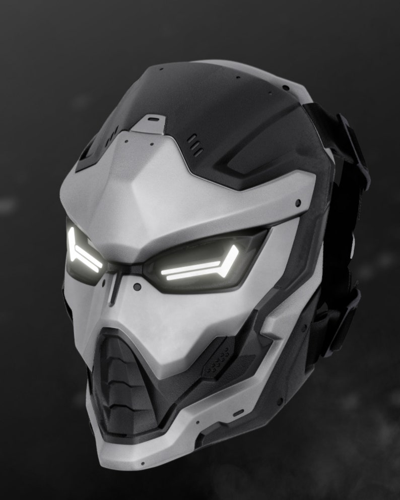 May include: A futuristic helmet with a white and black design. The helmet has a visor with white lights and a black strap.