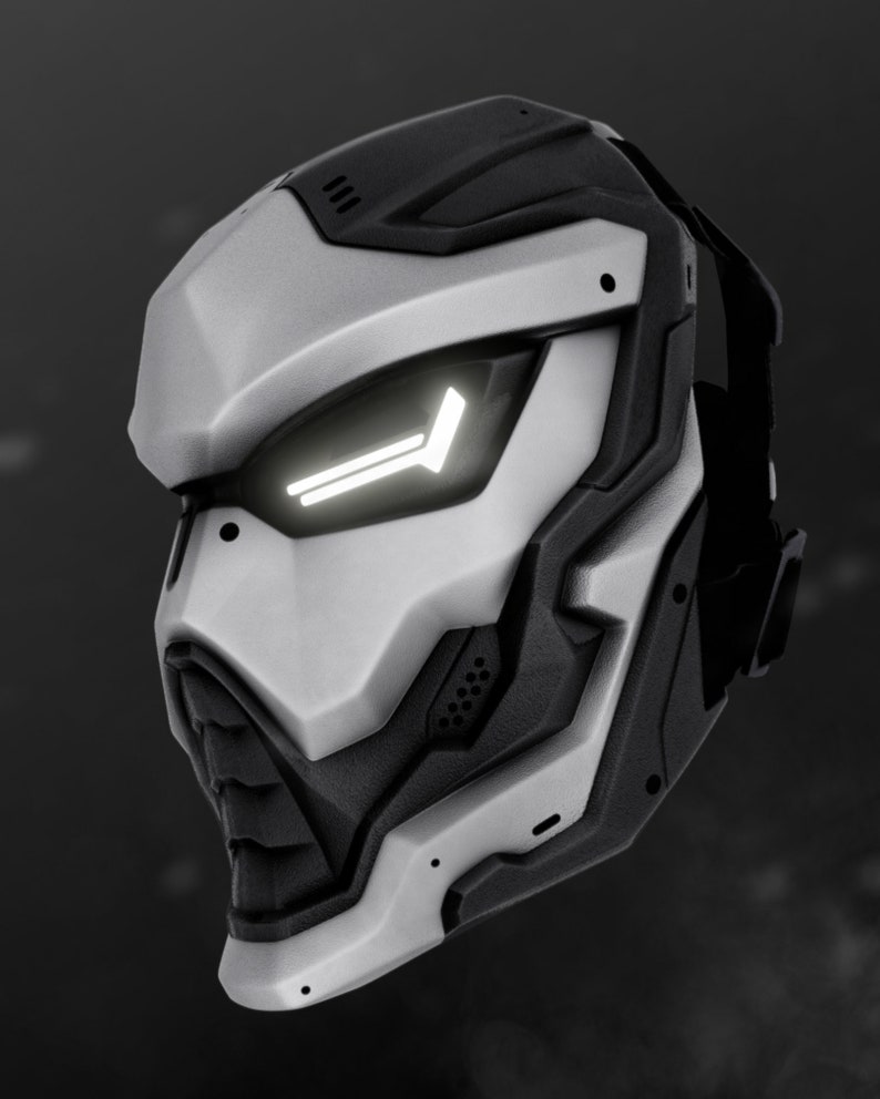 May include: A futuristic, silver and black helmet with a white light strip on the front. The helmet has a sleek, angular design and appears to be made of durable materials.