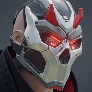May include: A futuristic helmet with a white and gray design, red horns, and glowing red eyes.