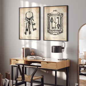 May include: Two black framed prints of vintage illustrations of keys. The prints are hanging on a light gray wall above a wooden desk with a black chair and a black lamp.