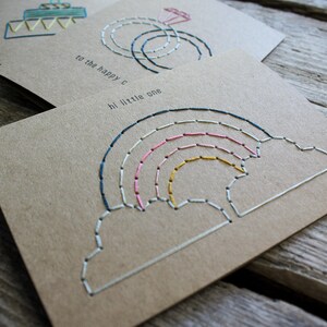 Handmade baby and expecting card showing the intricate, carefully hand stitched rainbow and cloud design.