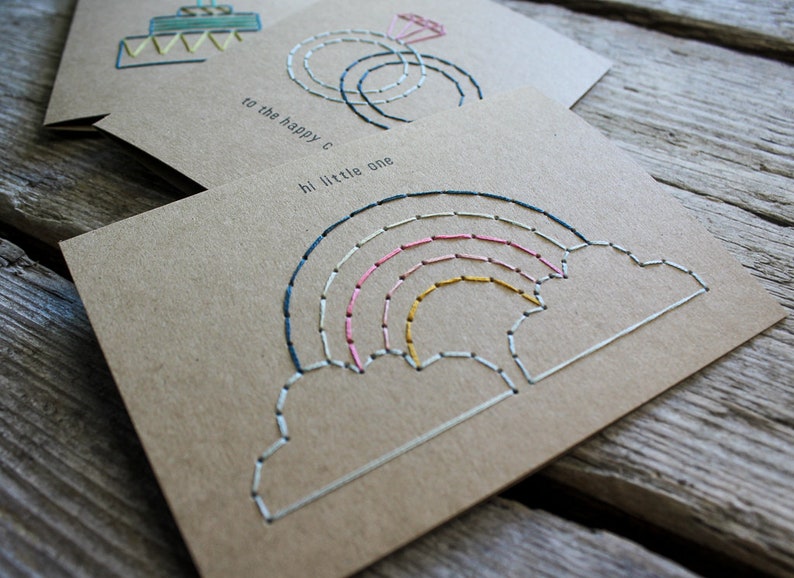 Handmade baby and expecting card showing the intricate, carefully hand stitched rainbow and cloud design.