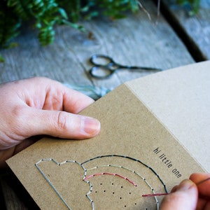 Hand stitching the new born baby - hi little one - greeting card with pastel coloured thread.