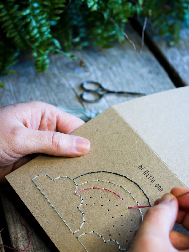 Hand stitching the new born baby - hi little one - greeting card with pastel coloured thread.