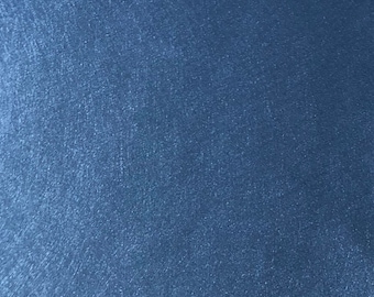Könnte beinhalten: Nahaufnahme einer strukturierten, einfarbigen blauen Oberfläche. Die Oberfläche hat einen subtilen, schimmernden Effekt mit sichtbaren feinen Linien und einer leicht unebenen Textur. Die Farbe ist ein tiefes, sattes Blau.