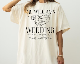 May include: Cream-colored oversized t-shirt with black text and graphic. The text reads "THE WILLIAMS WEDDING" above a drawing of two intertwined rings. Below the rings, the text reads "NASHVILLE, TN | 9.15.2025" and "Emily and Nathan".