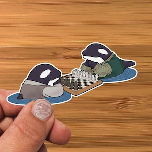 May include: Two black and white orcas playing chess on a black and white chessboard. The orcas are wearing clothes and are sitting on a blue and white background.