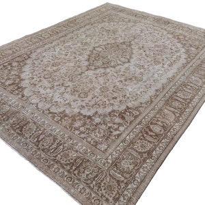 Peut inclure: Un tapis vintage avec un motif floral brun clair et blanc. Le tapis a une bordure d&eacute;taill&eacute;e avec un motif paisley.
