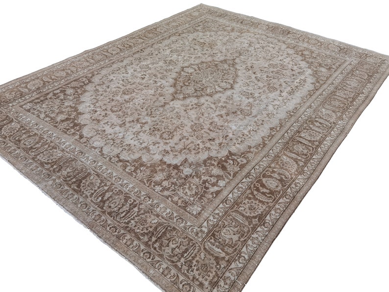 Peut inclure: Un tapis vintage avec un motif floral brun clair et blanc. Le tapis a une bordure d&eacute;taill&eacute;e avec un motif paisley.