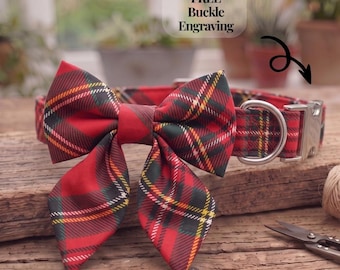 May include: A red, green, and yellow tartan pet collar featuring a large matching bow tie, a silver metal D-ring, and a silver buckle. The collar includes text that reads FREE Buckle Engraving with an arrow pointing toward the buckle.