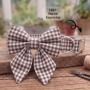 Puede incluir: Un collar para mascota con estampado de cuadros vichy en marrón y blanco, que incluye una pajarita grande de doble capa. El collar cuenta con una hebilla de metal plateado de apertura lateral y una anilla en D. El texto dice: FREE Buckle Engraving.
