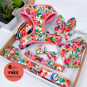 Puede incluir: Un conjunto de seis accesorios para mascotas con estampado floral, que incluye un arn&eacute;s, una correa, un collar, una pajarita, una bandana y una flor. Los accesorios presentan un vibrante estampado floral con flores rosas, naranjas y azules sobre un fondo blanco.