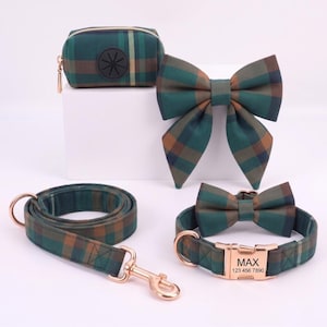May include: A pet accessory set featuring a green and brown plaid pattern, including a waste bag dispenser, a large bow, a leash with a rose gold metal clip, and a collar with a rose gold buckle engraved with the text MAX 123 456 7890.