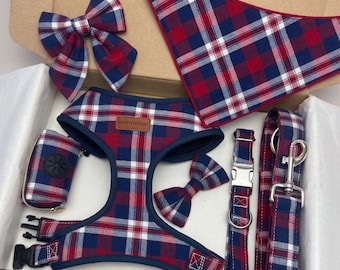 May include: A pet accessory set featuring a red, navy blue, and white plaid pattern. The set includes a harness with a HappyFurpaws label, a bandana, a leash with a metal clip, a collar with a metal buckle, two bow ties, and a small waste bag pouch.