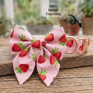 Puede incluir: Conjunto de collar y pajarita rosa para perros con estampado de fresas. La pajarita está unida al collar, que tiene una hebilla de oro rosa. El texto "FREE Buckle Engraving" es visible.