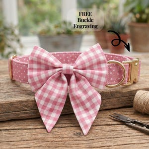 May include: Pink dog collar with white polka dots and a large gingham bow. The collar has a gold-colored buckle and a matching D-ring. The text "FREE Buckle Engraving" is visible in the image.