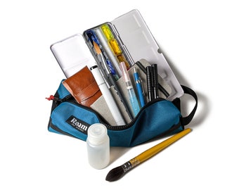 May include: A blue canvas bag with the word "Roam" printed on it, filled with art supplies including a watercolor palette, brushes, pens, and pencils. A clear plastic bottle and a yellow paintbrush are also visible.