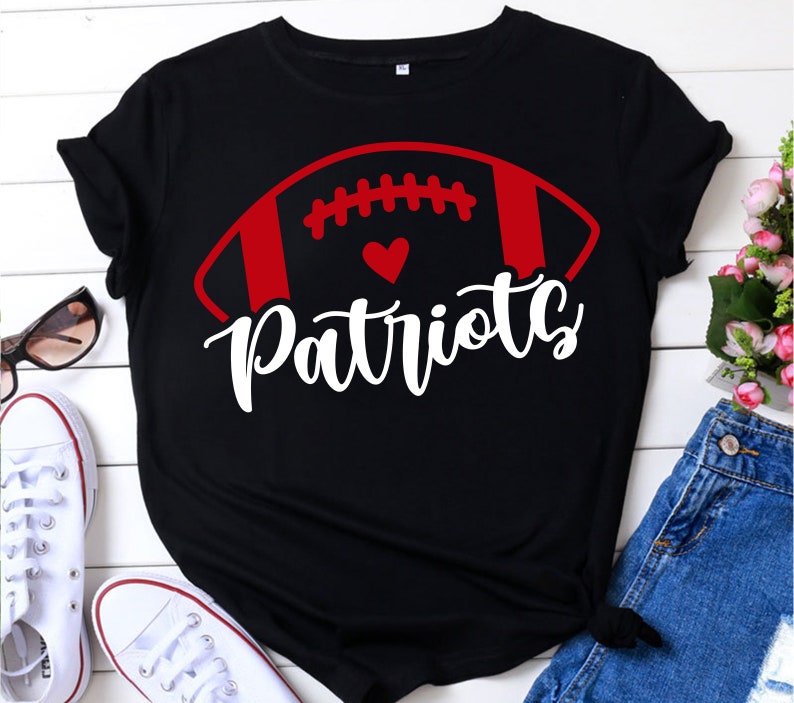 May include: Black t-shirt with a red and white football graphic and the word "Patriots" in white lettering.