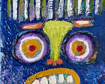 May include: A blue abstract painting of a face with purple eyes, a yellow nose, and a gold mouth with white teeth.