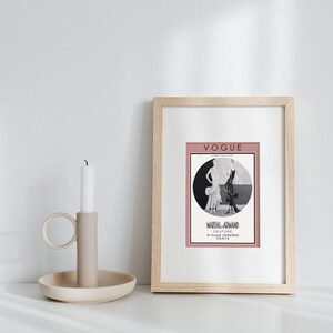 Może przedstawiać: Wydruk w ramie vintage okładki magazynu Vogue z czarno-białą ilustracją dw&oacute;ch kobiet w sukienkach. Okładka jest r&oacute;żowa z tekstem "Vogue" i "Martial-Armand Couture 10 Place Vendome Paris" w kolorze czarnym.