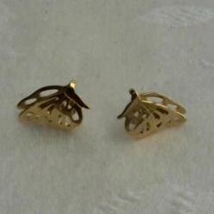 May include: A pair of gold-tone butterfly-shaped earrings. The earrings are made of a delicate, openwork design.
