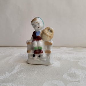 VINTAGE Porcelain Little Girl Sitting on Fence holding a Woven Basket and a Small Puppy on the bottom/Made in Japan/Mid Century Collectible