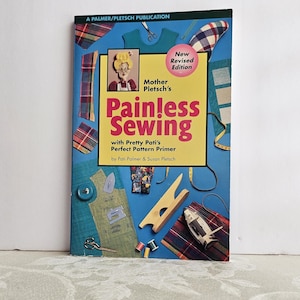 May include: A book titled "Painless Sewing" with a yellow and red cover, featuring illustrations of sewing tools and fabric swatches. The book is a "New Revised Edition" by Mother Pletsch, with Pretty Pati's Perfect Pattern Primer.