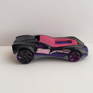 May include: A black and pink toy race car with purple wheels and the number 32 on the side.