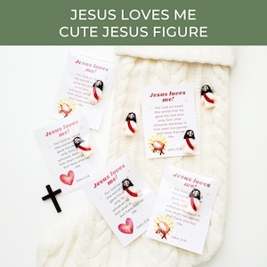 May include: A collection of religious-themed items, including small Jesus figures, cards with the text "Jesus loves me!" and a wooden cross. The cards feature a heart and a depiction of a manger. The text "Cute Jesus Figure" is at the top.