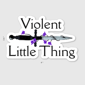 Op de afbeelding: Een sticker met de tekst "Violent Little Thing" en een zwart dolk-ontwerp versierd met paarse bloemen. De sticker is ongeveer 10 cm breed en 6,6 cm hoog.