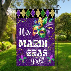 Può includere: Bandiera da giardino viola con una maschera di Mardi Gras, perline e il testo "It's Mardi Gras y'all".