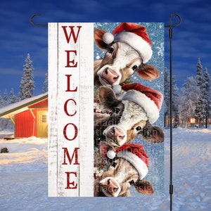 May include: A white wooden sign with the word "WELCOME" in red letters. Three cows wearing Santa hats peek out from behind the sign. The background is a snowy winter scene.