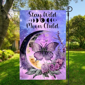 Może przedstawiać: Fioletowa flaga ogrodowa z półksiężycem, motylem i kwiatami. Tekst "Stay Wild Moon Child" jest napisany czarnymi literami.