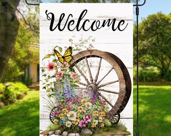 May include: A white wooden sign with the word "Welcome" in black script. A vintage wagon wheel is partially visible behind a cluster of colourful flowers and a yellow butterfly.