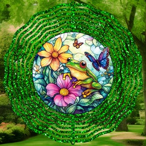 May include: A green metal wind spinner with a circular stained glass design featuring a frog, butterflies, and flowers. The wind spinner has a green glitter finish.
