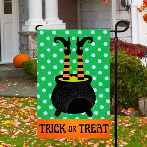 May include: A green and white polka dot garden flag with a black cauldron and witch's legs sticking out of it. The text "Trick or Treat" is printed in orange on the bottom of the flag.