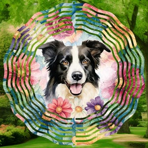 May include: A metal wind spinner featuring a watercolor painting of a black and white border collie dog surrounded by colorful flowers. The spinner has a layered, circular design with a blue, green, and yellow color scheme.