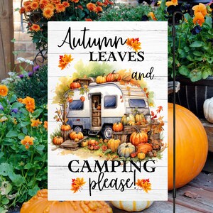 Könnte beinhalten: Ein weißer Wohnwagen mit Kürbissen auf dem Dach und drumherum. Der Text "Herbstblätter und Camping bitte!" steht auf einem weißen Holzschild mit Herbstblättern.
