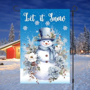 May include: A winter-themed garden flag featuring a watercolor snowman with a top hat, scarf, and floral accents. The flag has the text "Let it Snow" in a script font, set against a blue background with snowflakes.