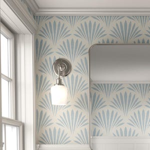 May include: A light blue bathroom vanity with a marble countertop, two drawers, and a lower shelf with a woven basket. The vanity is set against a wall with a blue and white fan pattern wallpaper. A rectangular mirror hangs above the vanity.