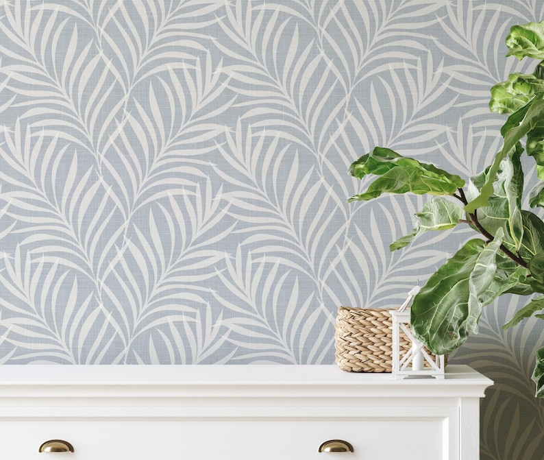 tropical boho palm leaf wallpaper in soft calm blue and white shown in removable peel and stick or prepasted. Perfect for modern coastal bathroom, powder room, nursery or laundry room accent wall.