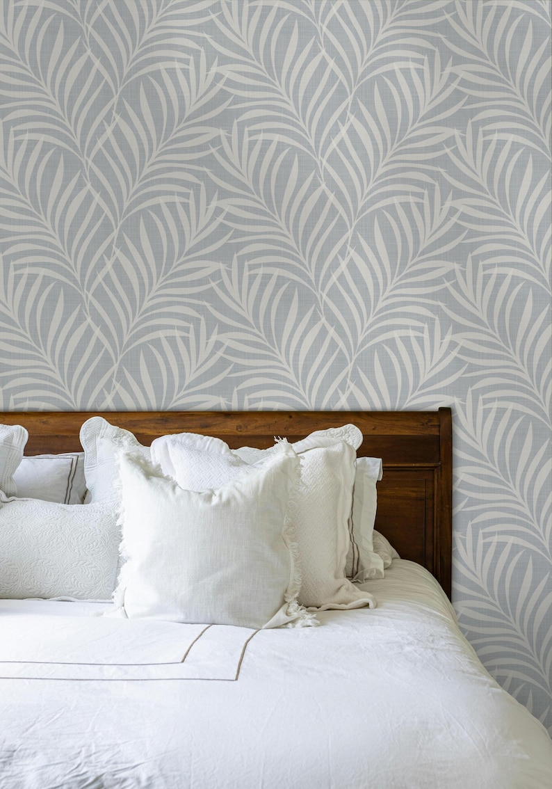 tropical boho palm leaf wallpaper in soft calm blue and white shown in removable peel and stick or prepasted. Perfect for modern coastal bathroom, powder room, nursery or laundry room accent wall.