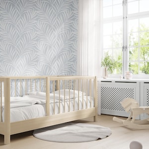 tropical boho palm leaf wallpaper in soft calm blue and white shown in removable peel and stick or prepasted. Perfect for modern coastal bathroom, powder room, nursery or laundry room accent wall.