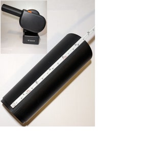 May include: A black cylindrical object with a white measuring tape wrapped around it. The tape measures 6 inches in length.