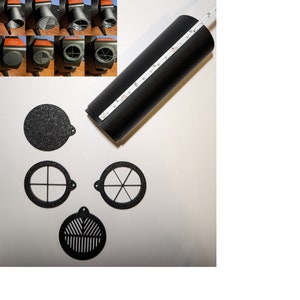 Pode incluir: Um conjunto de quatro tampas de ventilação de plástico preto para um tubo de 15,2 cm de diâmetro. As tampas têm diferentes designs, incluindo um círculo sólido, uma cruz, uma estrela e uma grade.