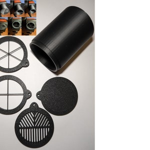 May include: A set of four black plastic filter attachments for a camera lens. The filters have different patterns of holes, including a cross, a circle, and a star.