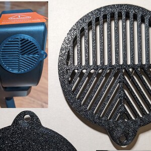 May include: Black plastic fan grill with a circular design and a small hole at the bottom. The grill has a textured surface and is designed to fit over a fan.