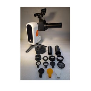 Może przedstawiać: Biało-czarny teleskop z małym pomarańczowym światełkiem z boku. Teleskop stoi na małym statywie i jest wyposażony w różne czarne i białe akcesoria, w tym czarną rurkę, czarny pierścień, czarny filtr i czarną osłonę.